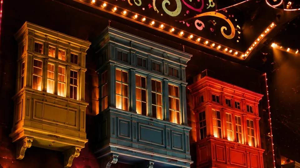 Three Maltese balconies, lit, on the stage wall