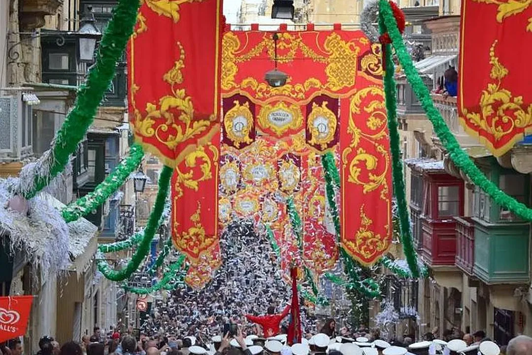 Reference photograph: Pavaljuni and garlands over a crowded festa street, beside the paper model rebuilt from it